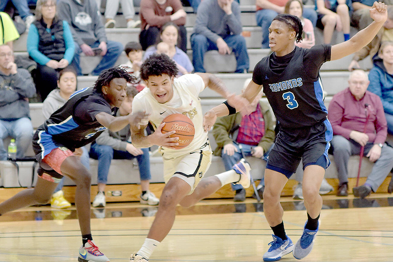 KEITH THORPE/PENINSULA DAILY NEWS 
Peninsula's Javon Ervin, center, pushes through the defense of Edmonds' Kalifa Ceesay, left, and Solomon Barnes on Saturday afternoon at Peninsula College.