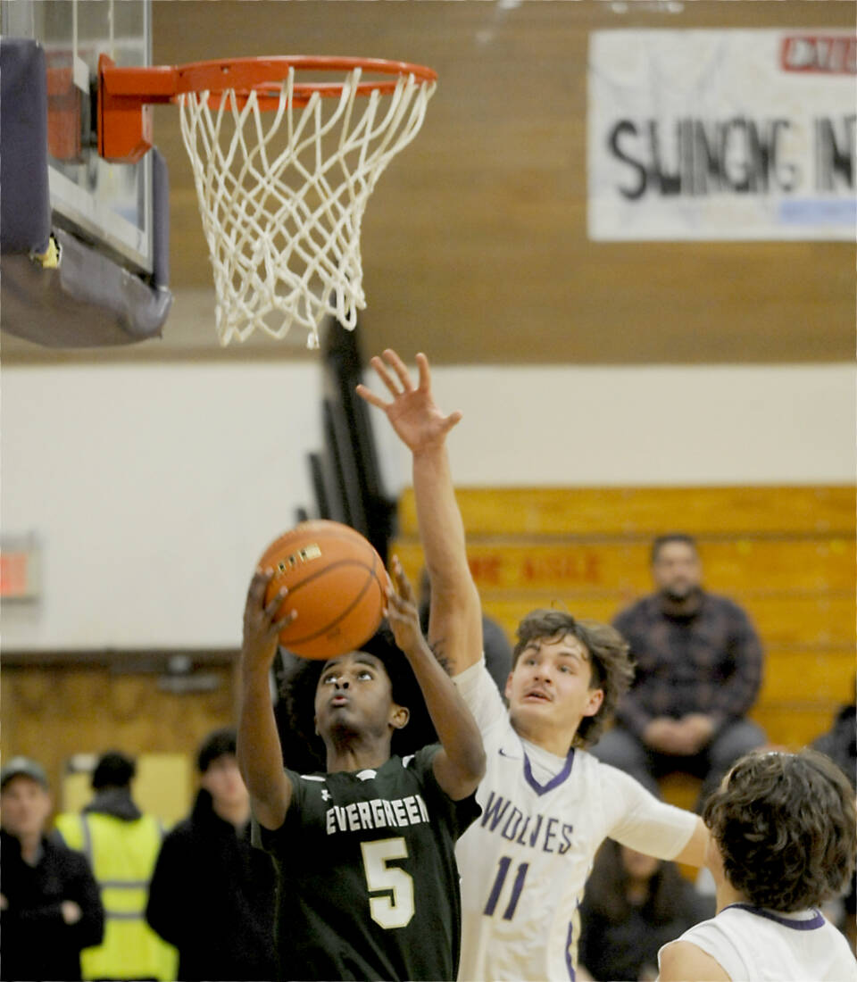 Sequim’s Charlie Grider (11) defends the rim against Evergreen’s Mohamed Abdi (5) in Tuesday’s bidistrict basketball playoff game in Sequim. (Michael Dashiell/Olympic Peninsula News Group)