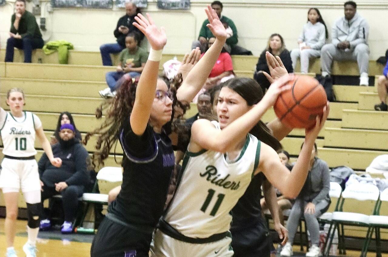 Port Angeles’ Lindsay Smith is surrounded by Foster defenders Wednesday night in Port Angeles in a bi-district playoff game. She scored 17 points as the Roughriders won 67-37 to qualify for the state 2A tournament. (Dave Logan/for Peninsula Daily News)