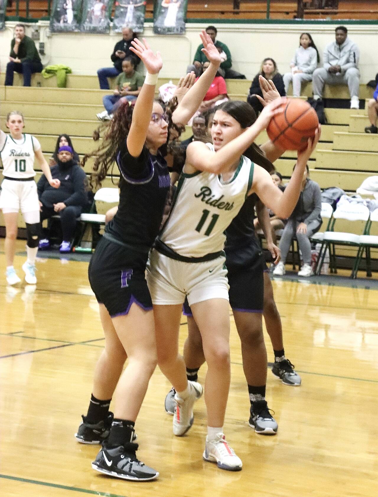 Port Angeles’ Lindsay Smith is surrounded by Foster defenders Wednesday night in Port Angeles in a bi-district playoff game. She scored 17 points as the Roughriders won 67-37 to qualify for the state 2A tournament. (Dave Logan/for Peninsula Daily News)