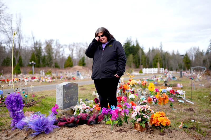 Evelyn Jefferson, a crisis outreach supervisor for Lummi Nation, stands at the grave of her son Patrick George Jr., who died last September due to an overdose of street drugs containing the synthetic opioid carfentanil, at the Lummi Nation cemetery on tribal reservation lands on Feb. 8 near Bellingham. Jefferson had to wait a week to bury her son due to several other overdose deaths in the community. (Lindsey Wasson/The Associated Press)