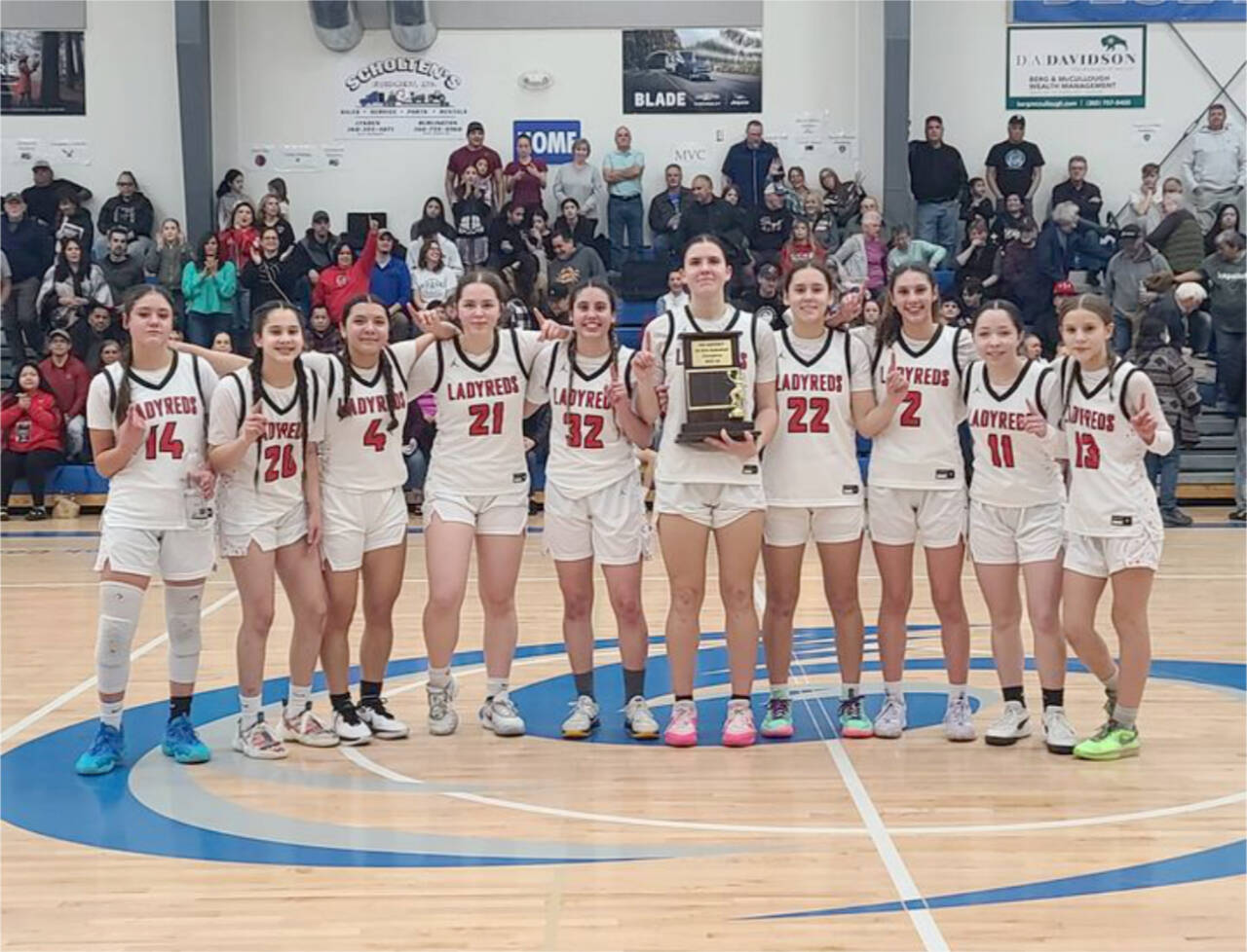 The defending state champion Neah Bay girls basketball team celebrates its tridistrict championship Saturday in Mount Vernon. (Courtesy photo)