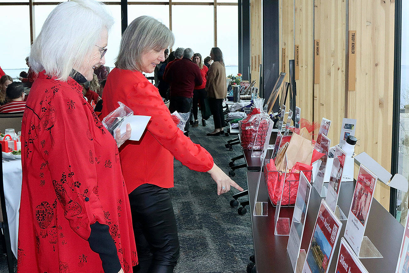 Mother and daughter Shelly Tweter and Peach Thompson look over silent auction items at the Red, Set, Go! event Friday at Field Arts & Events Hall in Port Angeles. (Dave Logan/for Peninsula Daily News)