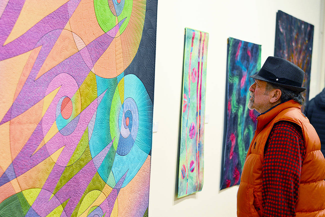 (Northwind Art Richard Coletta) 
Richard Coletta of Port Townsend admires Caryl Fallert-Gentry's quilt titled "Electric Snails," part of the "Burst of Color" exhibit at Jeanette Best Gallery.