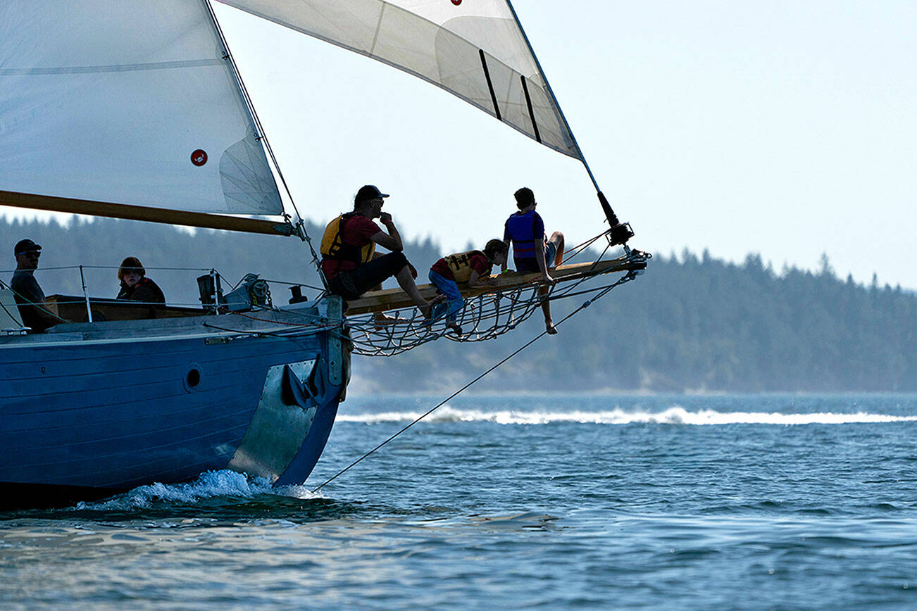 Steve Mullensky/for Peninsula Daily News

A perch on the bowsprit affords these spectators a wide open view of competing boats in a previous year's regatta on Port Townsend Bay.