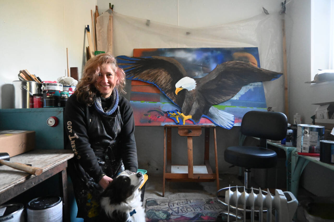 Melissa Klein takes a break from her work in her studio located north of Sequim. Joining her is her dog Stormy. (Michael Dashiell/Olympic Peninsula News Group)