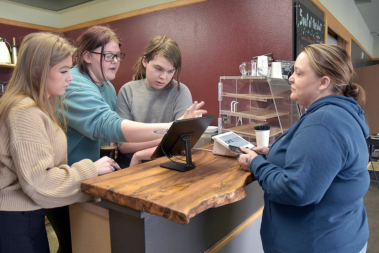 KEITH THORPE/PENINSULA DAILY NEWS
Coffee customer Lauren Wright of Port Angeles, right, gets assistance at the counter from Career and Technical Education program students, from left, Jordis Vance, 17, Rayin Blewett, 18, and Maple Romberg, 16, on Friday's opening day of the Wildcat Cafe at Lincoln Center in Port Angeles.