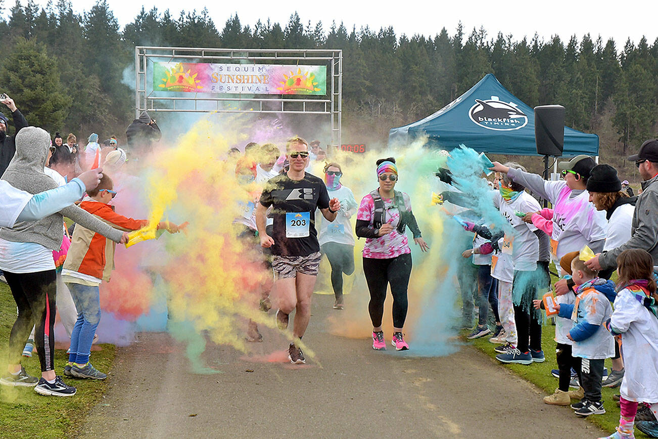 Participants in the Sequim Sunshine Festival 5K Sun Fun Color Run navigate through a gauntlet of tempera paint on Saturday at the Albert Haller Play Fields at Carrie Blake Park. The two-day festival, hosted by the City of Sequim, also featured food, music, youth activities, a craft fair and a drone show. (Keith Thorpe/Peninsula Daily News)