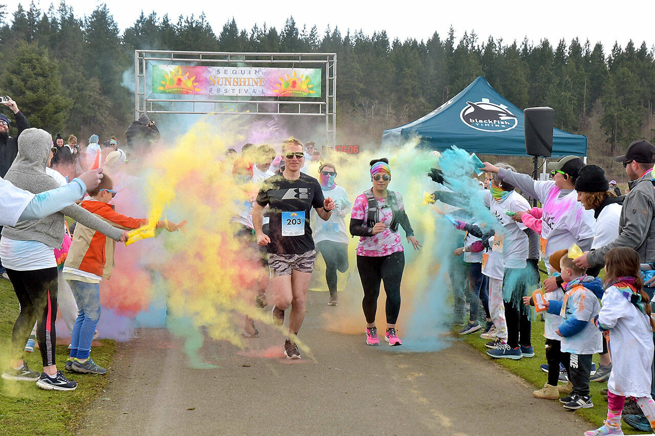 Participants in the Sequim Sunshine Festival 5K Sun Fun Color Run navigate through a gauntlet of tempera paint on Saturday at the Albert Haller Play Fields at Carrie Blake Park. The two-day festival, hosted by the City of Sequim, also featured food, music, youth activities, a craft fair and a drone show. (Keith Thorpe/Peninsula Daily News)