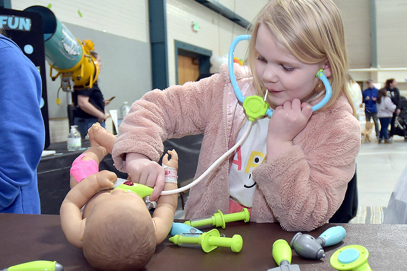 Skylar Sutherland, 5, of Port Angeles uses a toy stethoscope during a pretend examination of a doll at an information table set up by Olympic Medical Center’s New Family Services and Pediatrics departments during Saturday’s 35th annual Kids Fest at Vern Burton Community Center in Port Angeles. The event, hosted by Port Angeles Kiwanis, featured a variety of displays and information tables showcasing family and children’s services. Kids Fest also included numerous outdoor public safety displays organized by Clallam County Emergency Services. (Keith Thorpe/Peninsula Daily News)