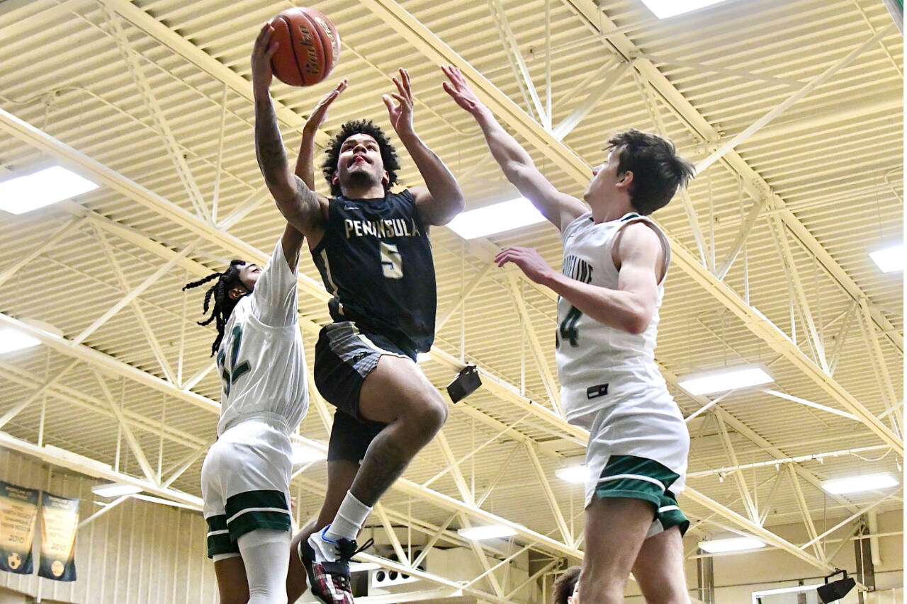 Peninsula College’s Javon Ervin drives to the hoop between Shoreline defenders Jordan Smalls, left, and Derek Nordale, right. Ervin scored 27 as Peninsula won 83-70 to advance to the NWAC Tournament. (Jay Cline/Peninsula College)