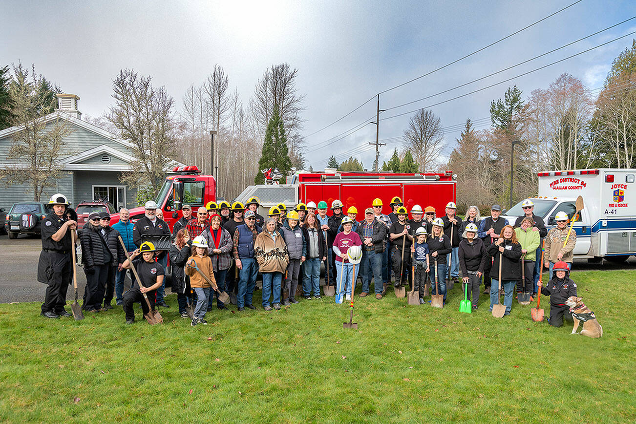 Roger Mosley 
Joyce community, donors and Joyce Fire District members gather for a groundbreaking ceremony at the site of the new equipment bay building to be constructed at 51162 Highway 112 in Joyce. The shovel with the helmet on top is in memory of the late Terry Barnett, a former commissioner who was instrumental in the building project before he died.