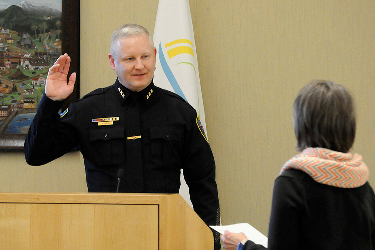 Mike Hill takes his oath of office on Friday from acting city clerk Heather Robley to become the City of Sequim’s new police chief. (Matthew Nash/Olympic Peninsula News Group)