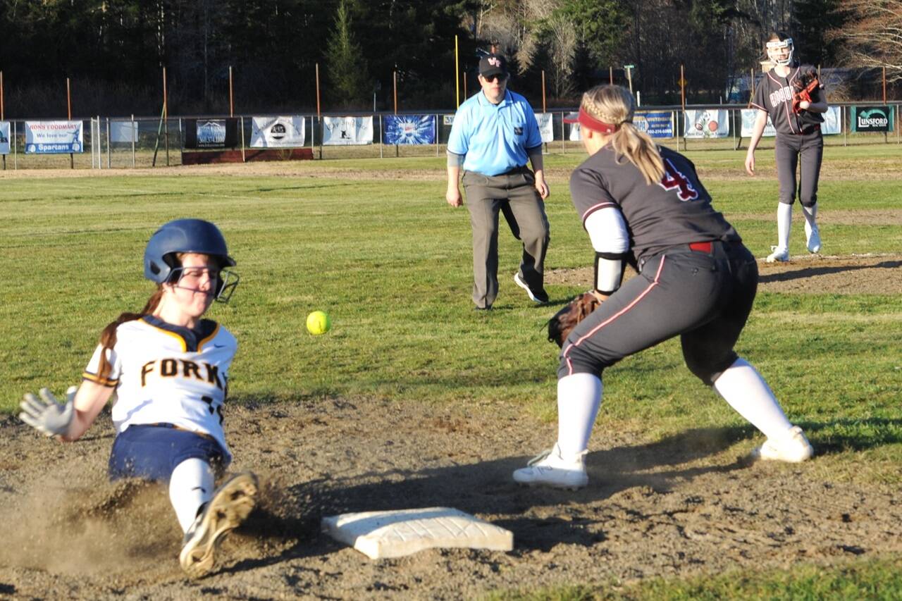 Forks' Chloe Gaydeski beats the throw to third as the Spartans defeated Hoquiam 20-15 in this slugfest at Fred Orr Park in Beaver. Covering third is Hoquiam's Macy Dhooghe. (Lonnie Archibald/for Peninsula Daily News)