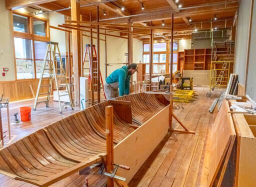 Joel Arrington, boat shop manager for the Northwest Maritime Center, looks at the bow of a boat he cut in half that will be an exhibit piece in the new Welcome Center being constructed in what was formerly the retail shop. The new space will have a smaller retail space with the rest of the floorplan devoted to exhibits. (Steve Mullensky/for Peninsula Daily News)