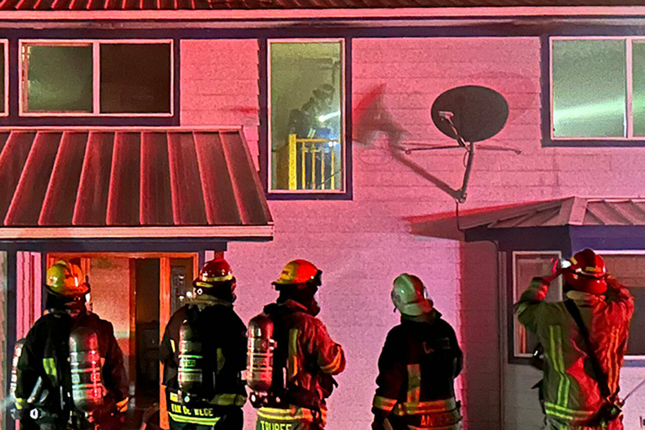 Clallam County Fire District 3 firefighters determine a course of action at a house fire Thursday to prevent flames going from the attic into the remainder of the home. (Matthew Nash/Olympic Peninsula News Group)