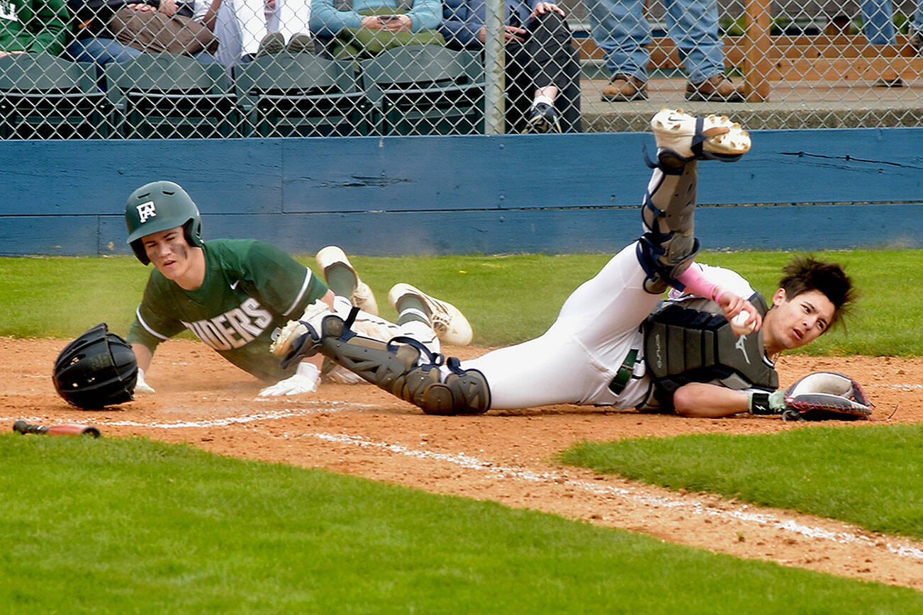 KEITH THORPE/PENINSULA DAILY NEWS
Port Angeles baserunner Alex Angevine, left, bowls over Peninsula catcher Jonathan Vegara-Dykes after a force out at the plate on Saturday afternoon in Port Angeles.