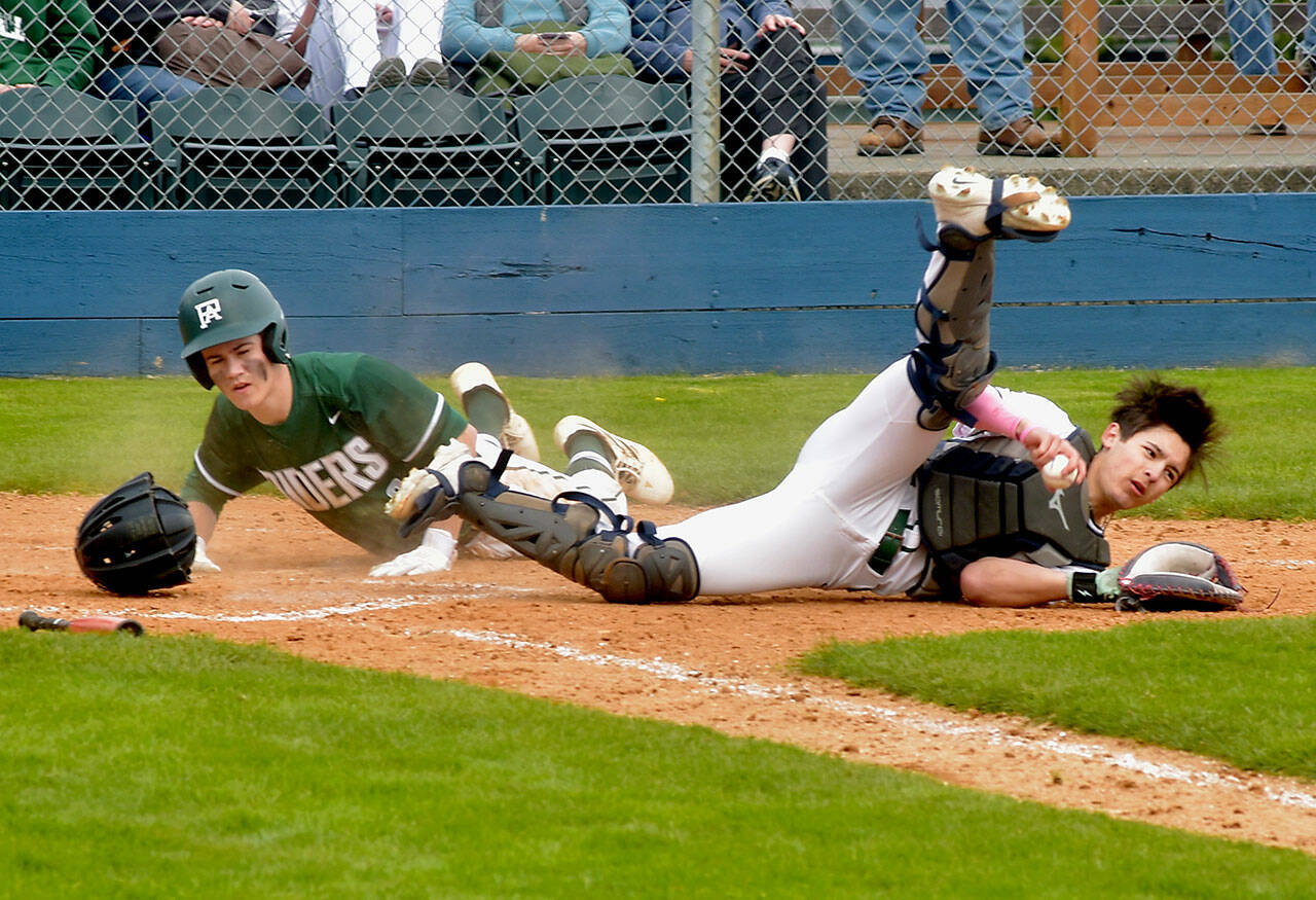 KEITH THORPE/PENINSULA DAILY NEWS Port Angeles baserunner Alex Angevine, left, bowls over Peninsula catcher Jonathan Vegara-Dykes after a force out at the plate on Saturday afternoon in Port Angeles.