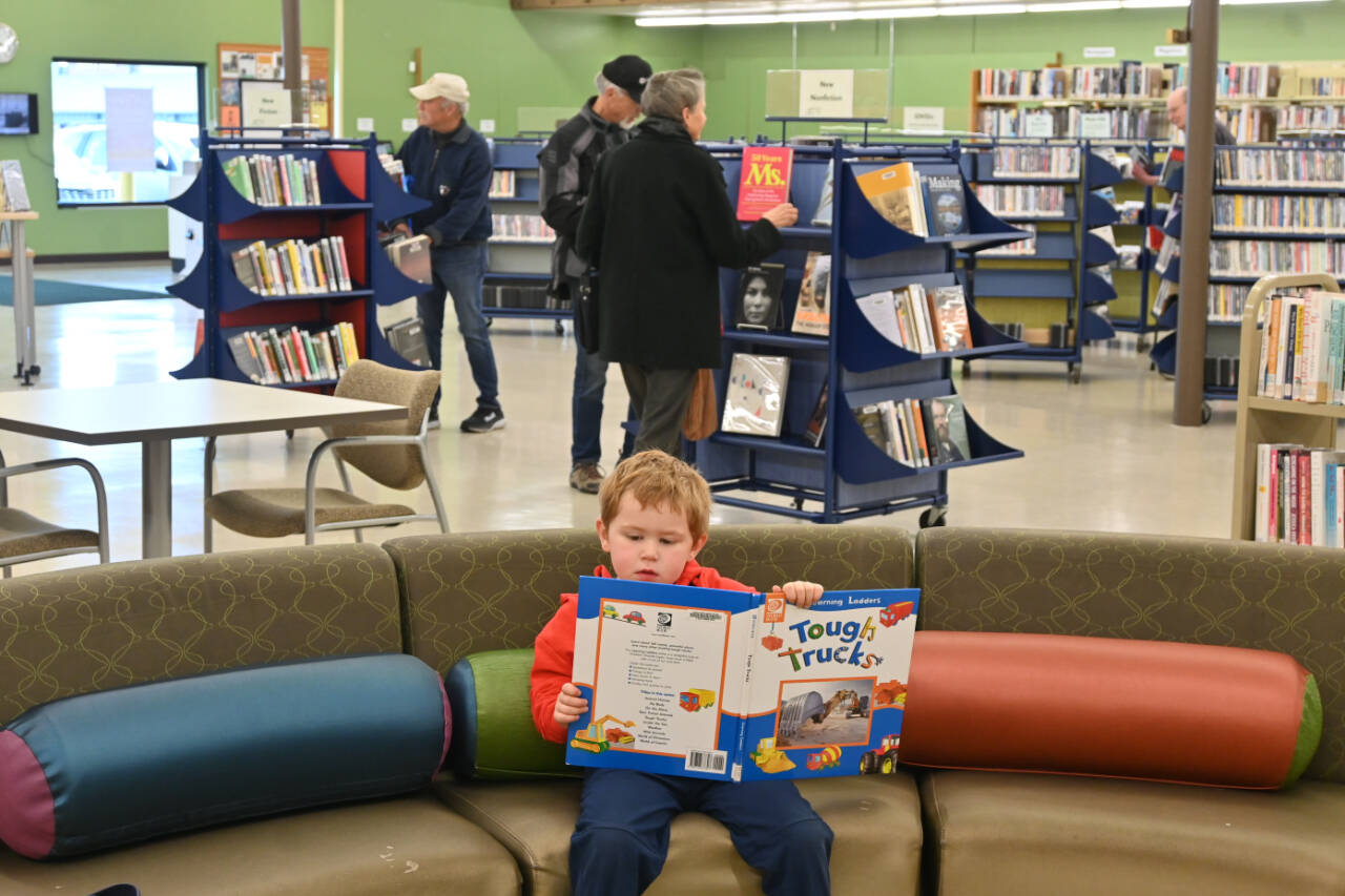 Francis Ward, 4, of Sequim digs into a book at the opening of the Sequim library’s temporary location on Monday. (Michael Dashiell/Olympic Peninsula News Group)
