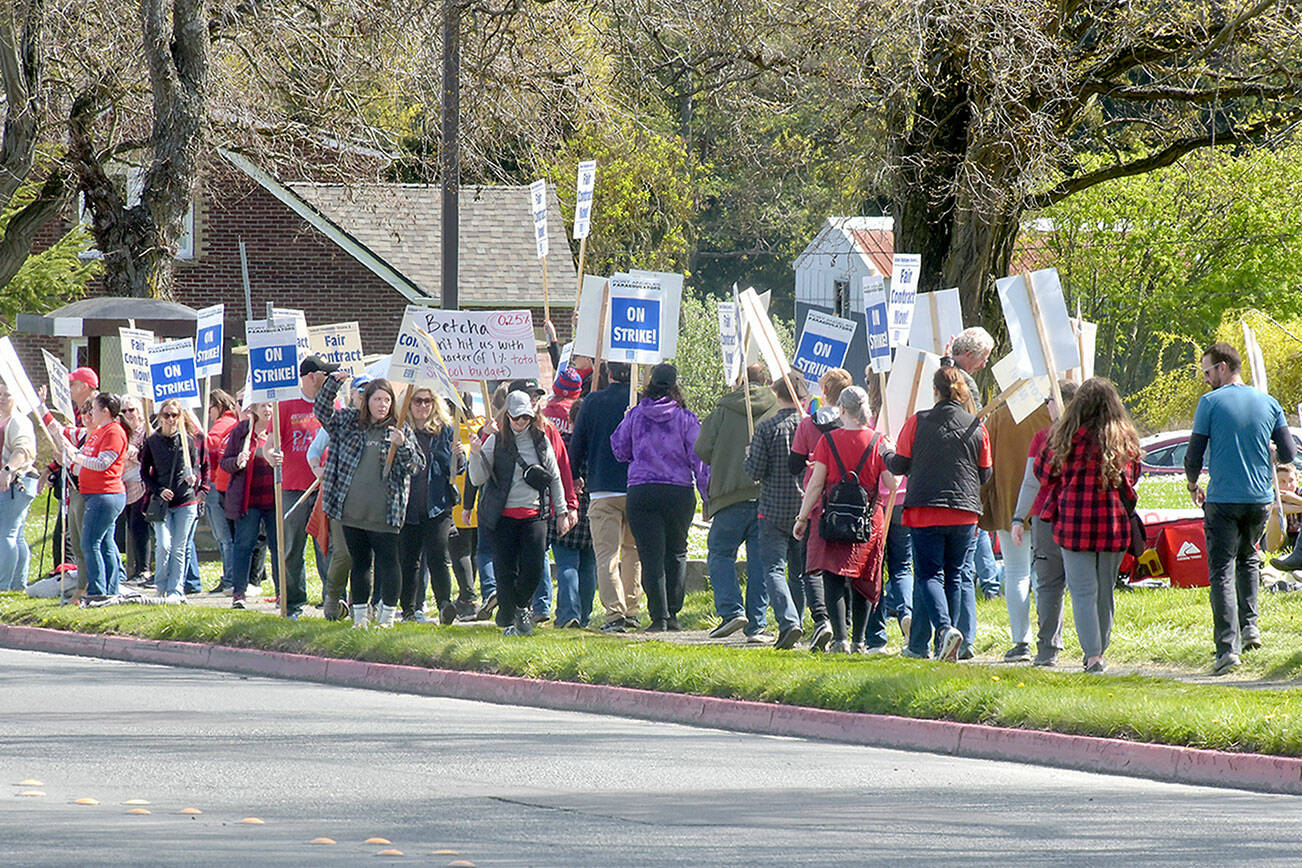 Pickets in support of paraeducators in the Port Angeles School District march along West Eighth Street in front of the district offices at Lincoln Center on Wednesday. (Keith Thorpe/Peninsula Daily News)