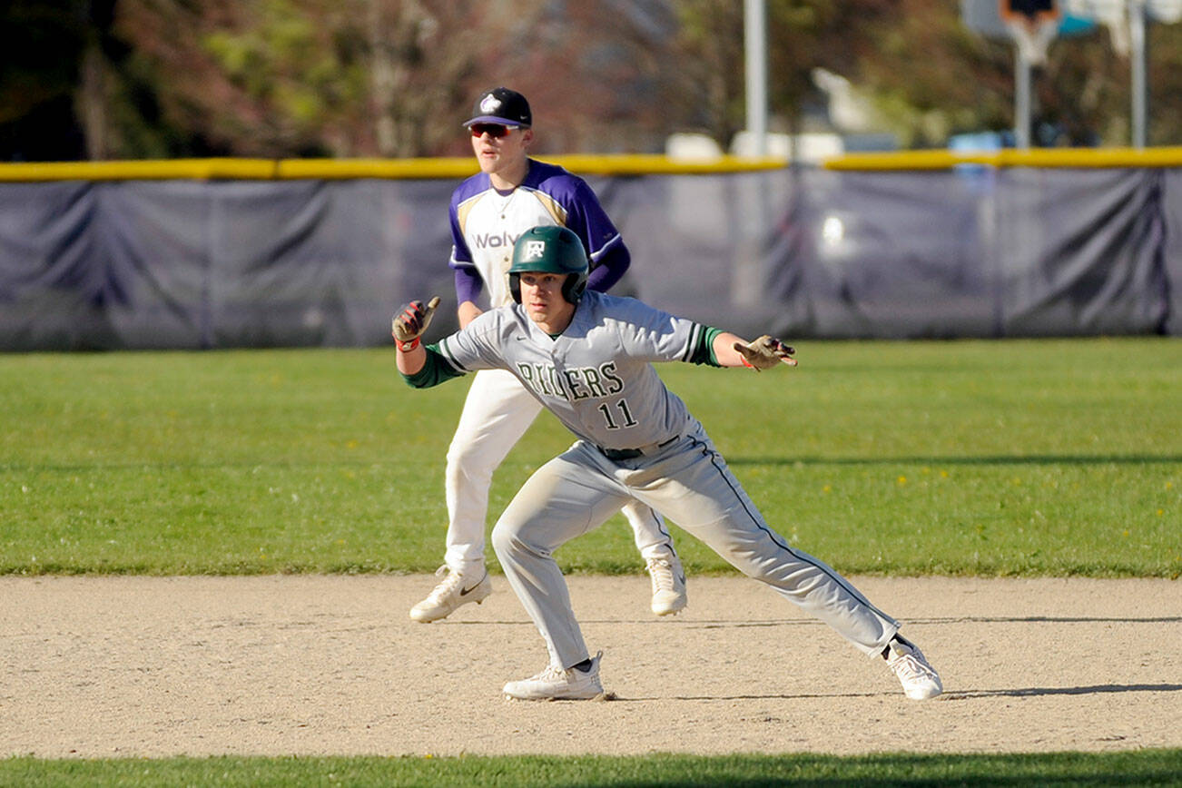 Port Angeles' Josiah Gooding (11) leads off of second base while Sequim shortstop Devyn Dearinger plays behind him in Sequim on Friday. The Roughriders won 7-4. (Michael Dashiell/Olympic Peninsula News Group)