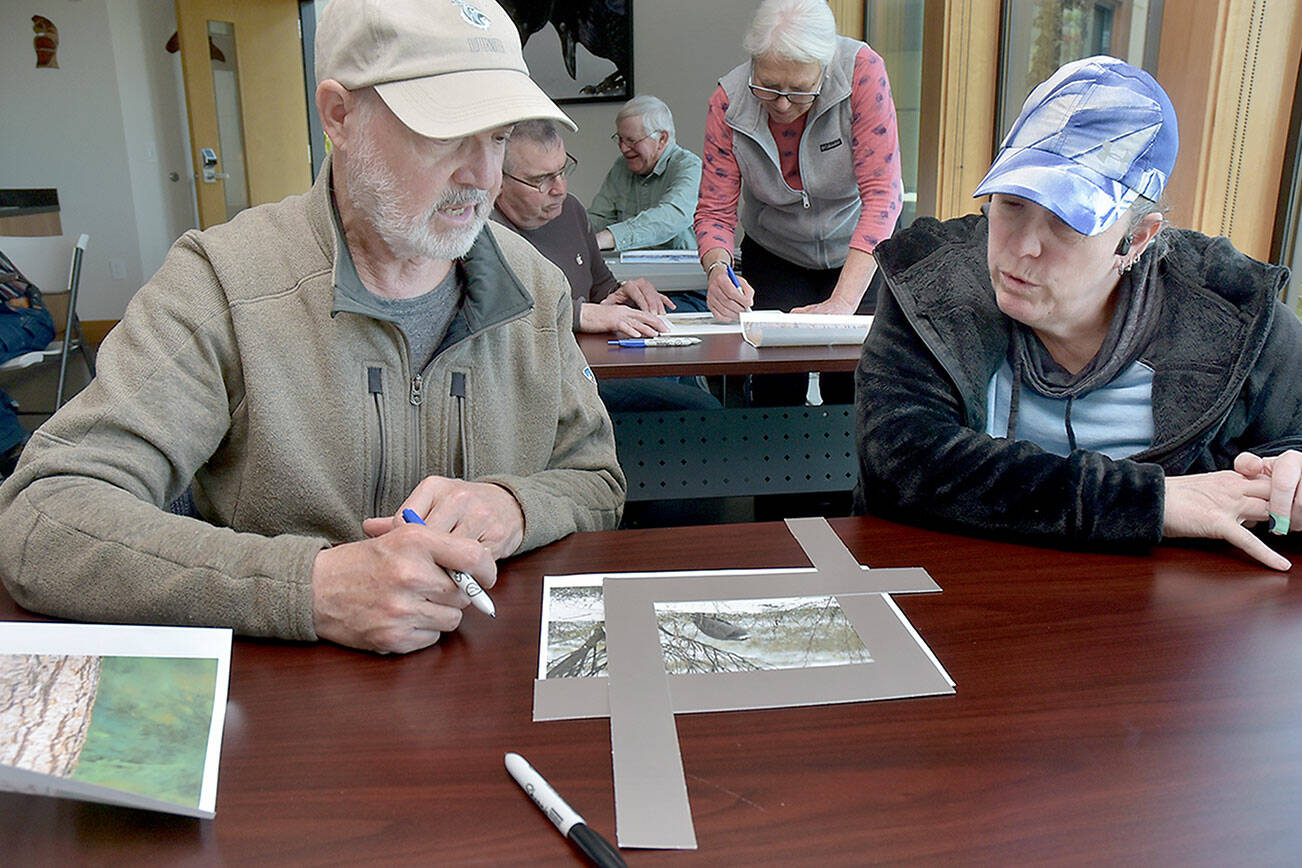 Dave Swinford of Sequim, left, and Marlana Ashlie of Victoria take part in a workshop on Saturday about cropping bird photos for best presentation during Saturday’s Olympic Birdfest. (Keith Thorpe/Peninsula Daily News)