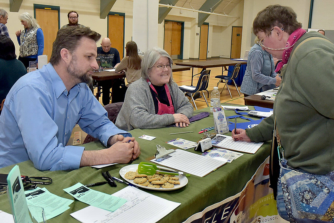 Amy DeQuay of Port Angeles, right, signs up for information at a table staffed by Christopher Allen and Mary Sue French of the Port Angeles Arts Council during a Volunteer Fair on Wednesday at Vern Burton Community Center in Port Angeles. The event, organized by the Port Angeles Chamber of Commerce, brought together numerous North Olympic Peninsula agencies that offer people a chance to get involved in their communities. (Keith Thorpe/Peninsula Daily News)