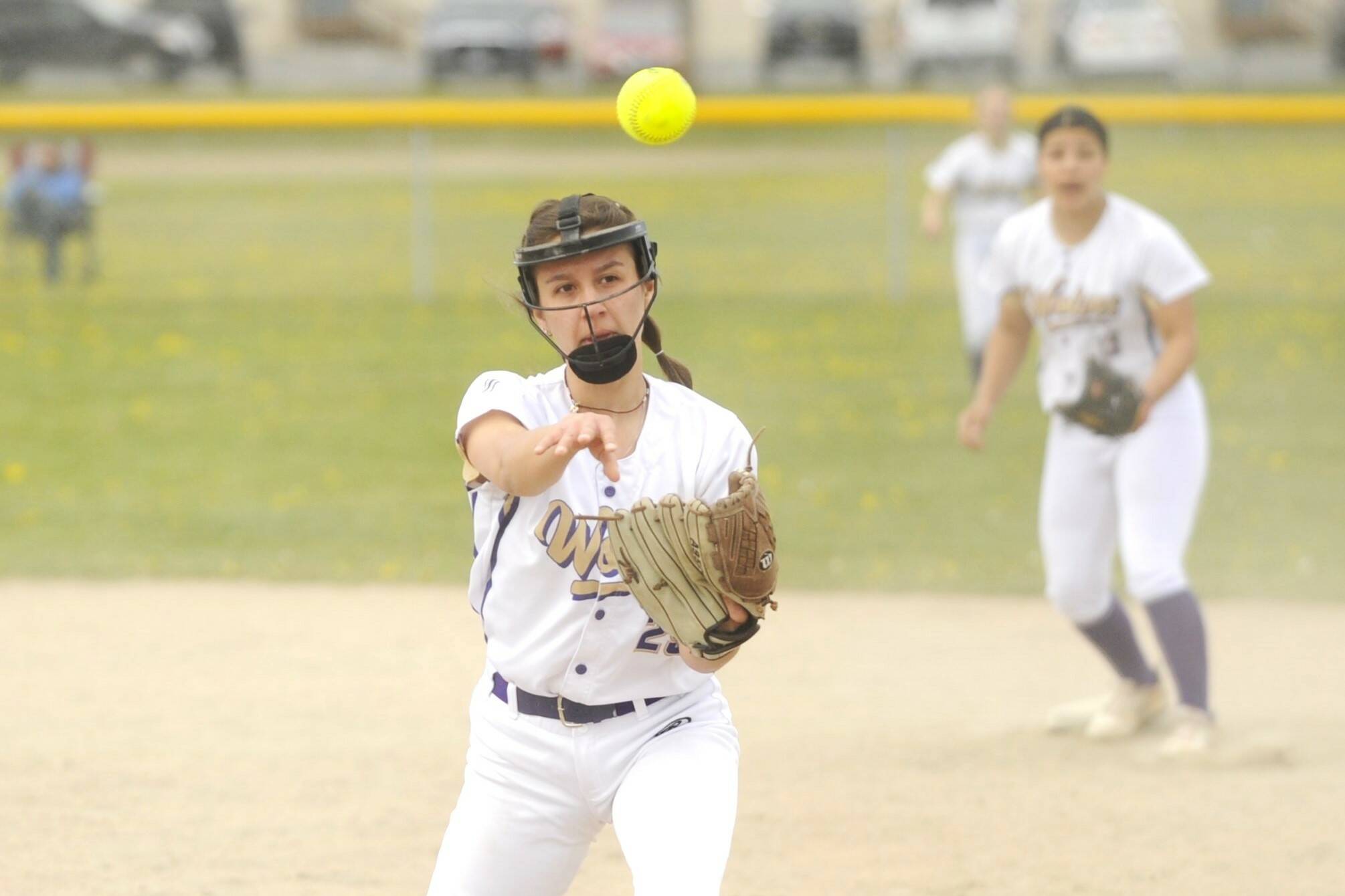 With teammate Taylee Rome looking on, Sequim second baseman Mia Kirner throws out a Klahowya running in a non-league match-up Saturday. Kirner had a home run in the windy game. (Michael Dashiell/Olympic Peninsula News Group)