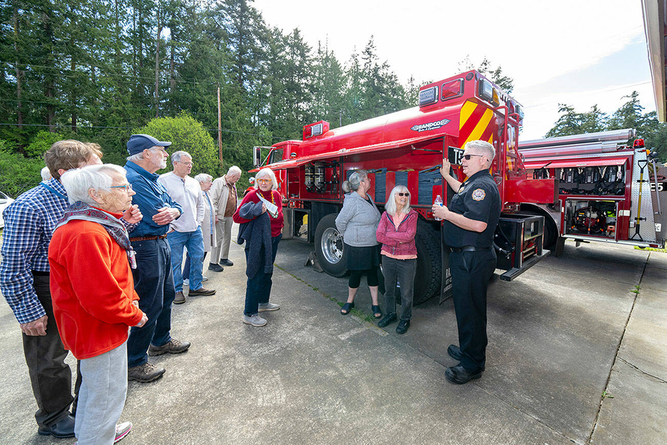 East Jefferson Fire Rescue Chief Bret Black describes the 2,500-gallon wildfire tender located at Marrowstone Fire Station 12 on Marrowstone Island during an open house on Saturday. (Steve Mullensky/for Peninsula Daily News)