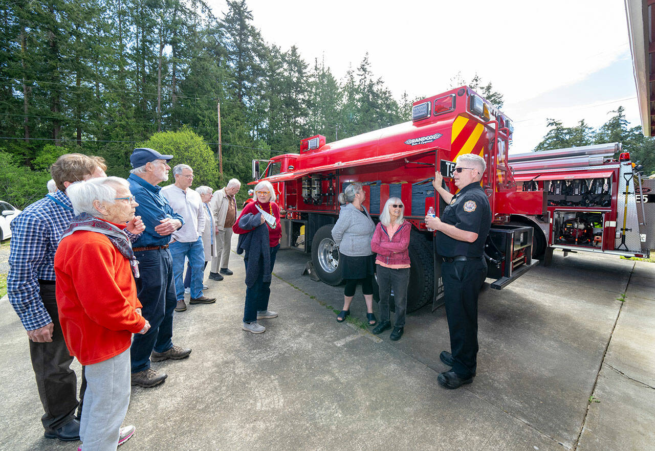 East Jefferson Fire Rescue Chief Bret Black describes the 2,500-gallon wildfire tender located at Marrowstone Fire Station 12 on Marrowstone Island during an open house on Saturday. (Steve Mullensky/for Peninsula Daily News)
