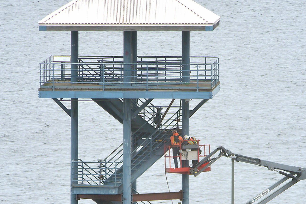 A repair crew performs work on the observation tower at the end of Port Angeles City Pier on Wednesday as part of a project to repair structural deficiencies in the tower, which has been closed to the public since November. The work, being performed by Aberdeen-based Rognlin’s Inc., includes replacement of bottom supports and wood decking, paint removal and repainting of the structure. Work on the $574,000 project is expected to be completed in June. (Keith Thorpe/Peninsula Daily News)