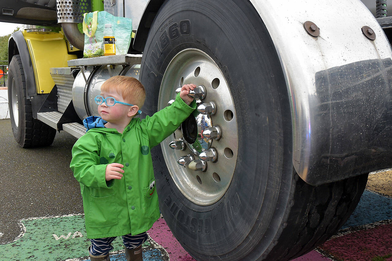 August Gala, 2, of Port Angeles spins an idle wheel of a truck belonging to Bruch & Bruch Construction during Saturday’s Touch a Truck event at Queen of Angeles School in Port Angeles. The event, hosted by the school’s parent-teacher organization, allowed youngsters and adults to visit and climb aboard a variety of construction, public safety and utility vehicles. (Keith Thorpe/Peninsula Daily News)