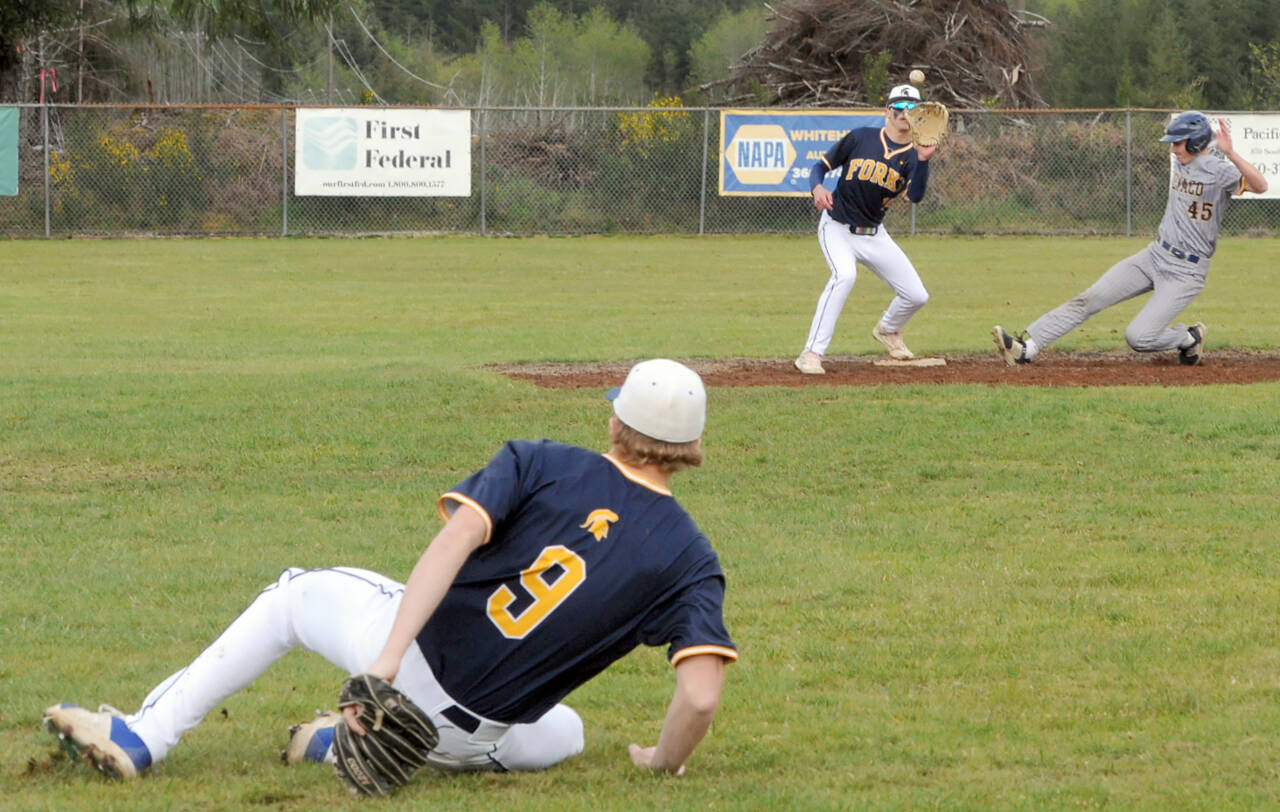 image Olson to Micheau=Forks shortstop Landen Olson (9) made a great play on a hard hit ground ball then while falling down, threw Ilwaco's runner E Hopkins (45) out on a force at second covered by Spartan Dylan Micheau.  Photo by Lonnie Archibald.