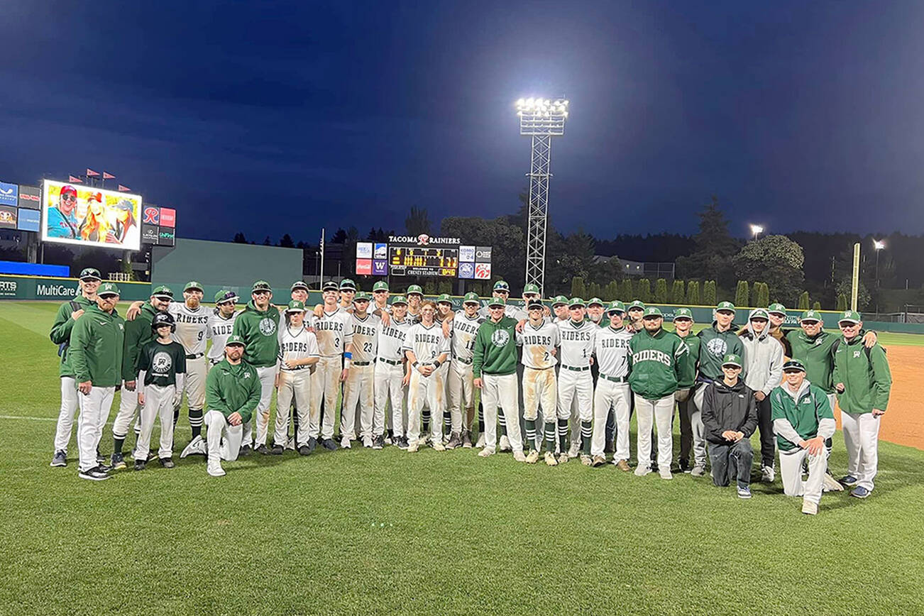 Port Angeles baseball players and coaches celebrate with a team photo on the field at Cheney Stadium after beating King's 6-5 Wednesday night in the Roughriders' regular season finale.
