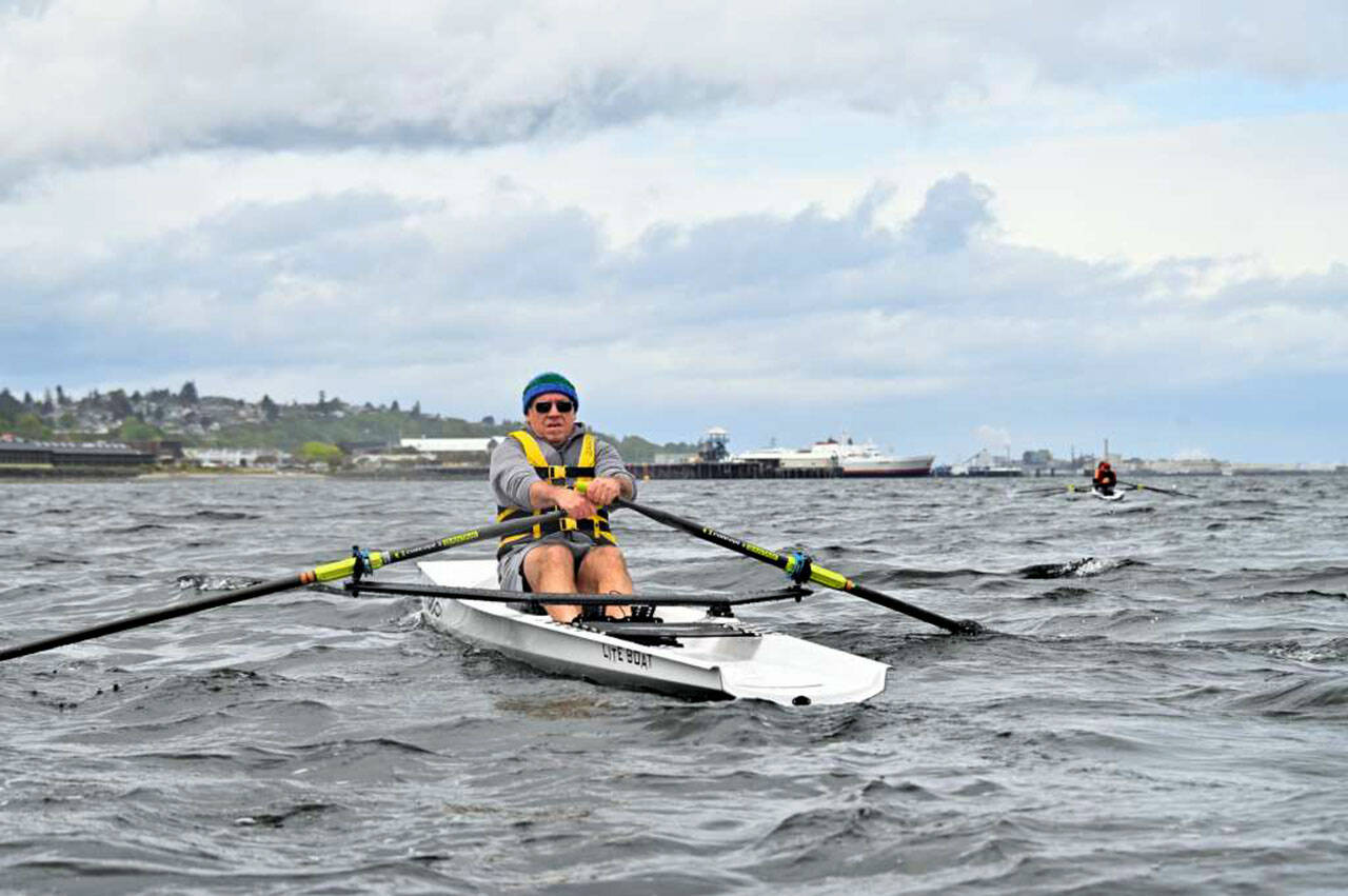 La Push’s James Lesniak makes his way upwind on Port Angeles Harbor during the first Edizgigantus Coastal Rowing Regatta with the MV Coho ferry and Red Lion Hotel in the background. (Olympic Peninsula Rowing Association)