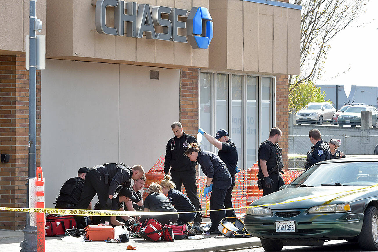 Police and rescue workers surround the scene of a disturbance on Friday morning at Chase Bank at Front and Laurel streets in downtown Port Angeles that resulted in a fatal shooting and the closure of much of the downtown area. (Keith Thorpe/Peninsula Daily News)