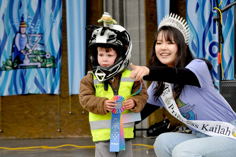 Bryant Volker smiles for Irrigation Festival photographer Keith Ross during the Kids Parade awards with help from festival Princess Kailah Blake. Volker won first place for his bicycle float. (Matthew Nash/Olympic Peninsula News Group)