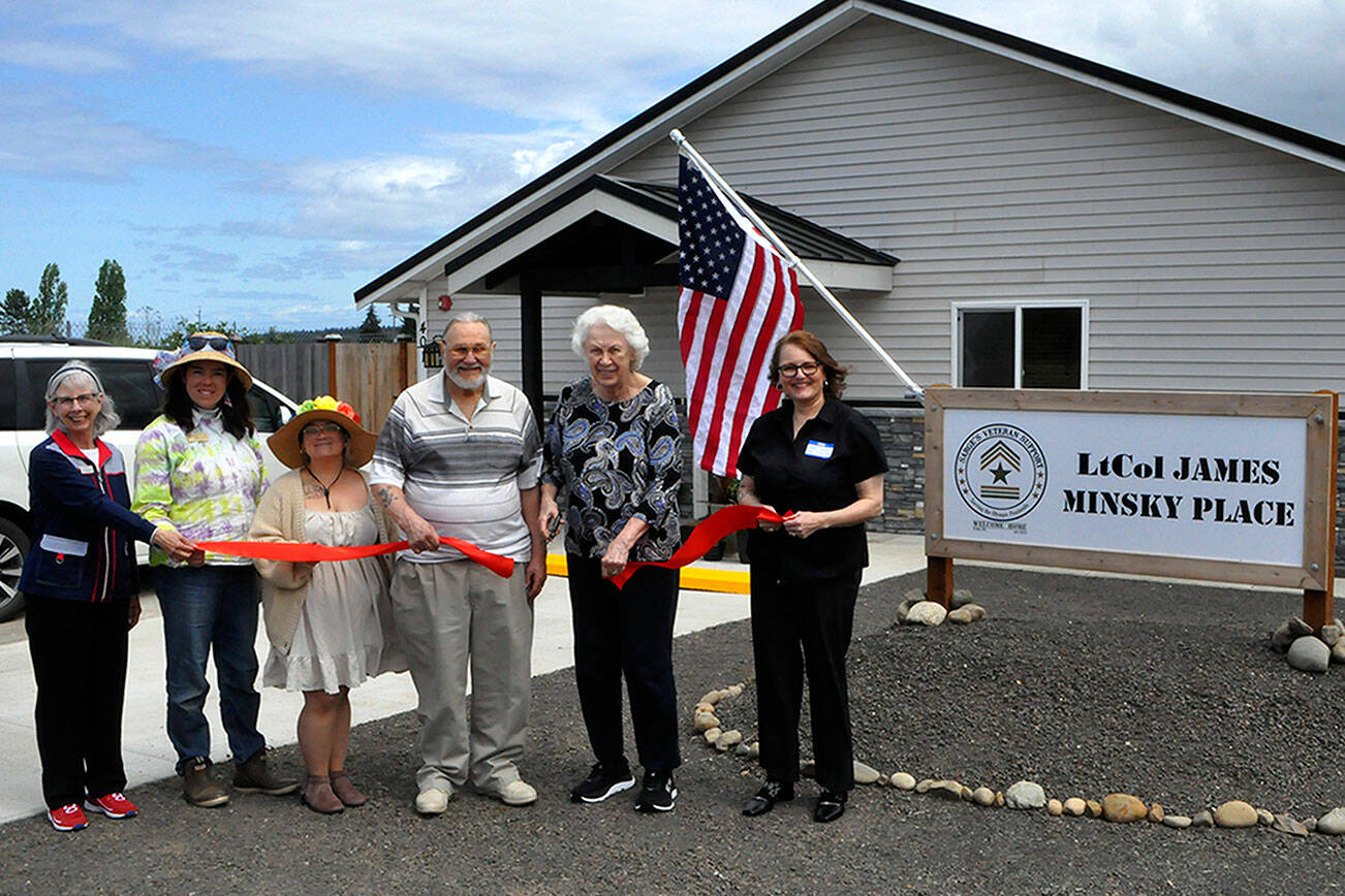 Helen and Greg Starr, executors of James Minsky’s estate, cut the ribbon for LtCol James Minsky Place on May 17 with Cheri Tinker, executive director of Sarge’s Veteran Support, right, and Sarge’s board president Lorri Gilchrist, and city council members Harmony Rutter and Rachel Anderson. The facility will permanently house six disabled and/or elderly veterans in Sequim. (Matthew Nash/Olympic Peninsula News Group)