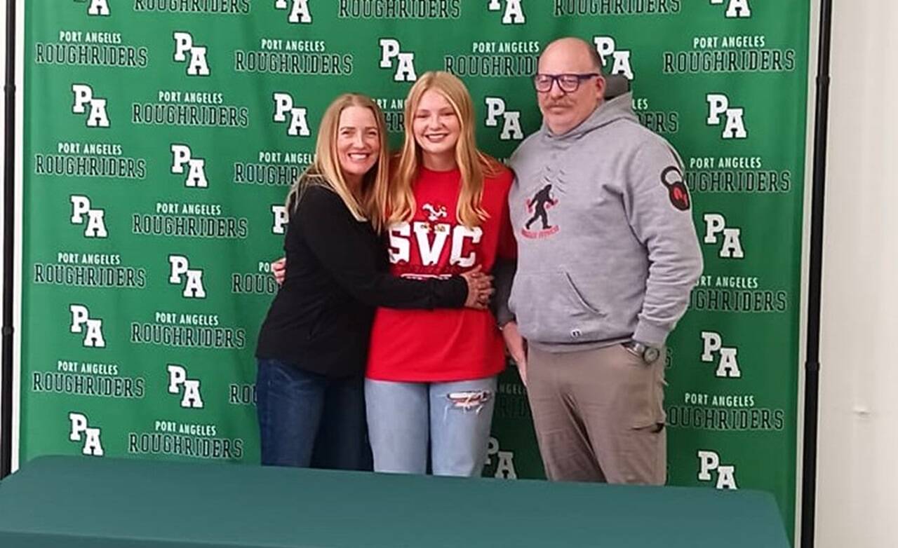 Port Angeles' Paige Mason on Wednesday signed to play both soccer and basketball for the Skagit Valley College Cardinals. From left are mother Dawn Mason, Paige Mason and father Rob Mason. (Pierre LaBossiere/Peninsula Daily News)