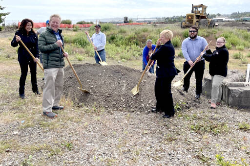 Port of Port Angeles commissioners Colleen McAleer, left, and Connie Beauvais, third from right, put shovels in the dirt at a groundbreaking ceremony on Sunday for the ports Marine Trade Center on the former Peninsula Plywood site on Marine Drive. Development of the 18-acre site will include installing utilities, paving and grading. Work is anticipated to be completed before the end of the year. The $10 million project was funded with a $7.3 million grant from the U.S. Economic Development Administration and $3.87 million from the port. From left to right, McAleer; Port Angeles City Manager Nathan West (partially hidden); Clallam County Commissioner Randy Johnson; Clallam County Commissioner Mike French; Lower Elwha Klallam Tribe Chairwoman Frances Charles; Beauvais; Michael Snodgrass, Olympic Peninsula Outreach Director for U.S. Sen. Maria Cantwell; and Haley Schanne, Director of Outreach for 6th Congressional District U.S. Rep. Derek Kilmer. (Paula Hunt/Peninsula Daily News)
