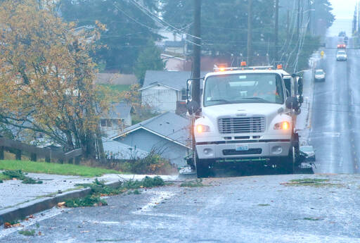 A street sweeper on I Street in Port Angeles cleans up the street along the curbs of all the debris that blew down during Tuesday evenings storm. Thousands were without power at the peak of the storm. (Dave Logan/for Peninsula Daily News)