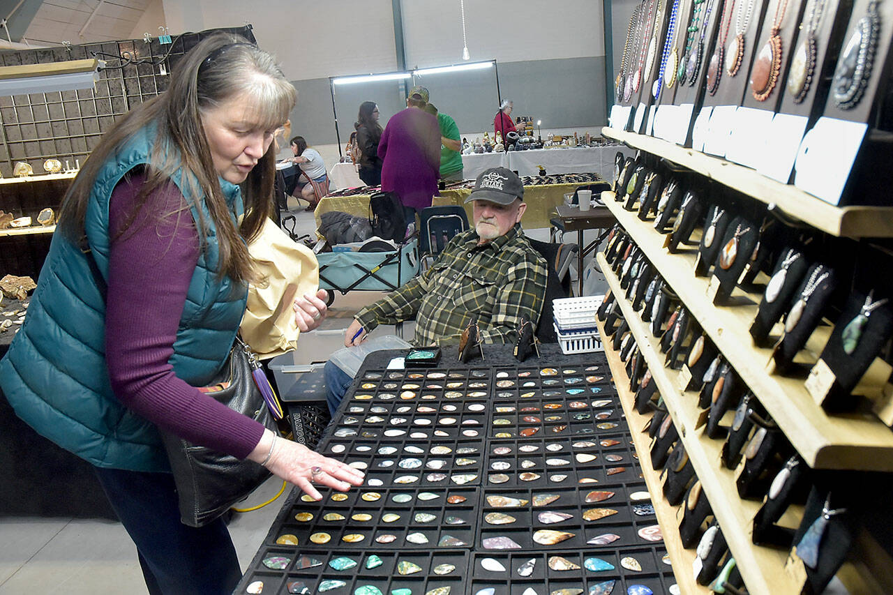 Jeannine Vaughn of Carlsborg looks a gems and jewelry at a display table operated by Steve Morgan of Joyce-based Lil Log Cabin Creations on Saturday at the Clallam County Rock, Gem and Jewelry Show at Vern Burton Community Center in Port Angeles. The show, hosted by the Clallam County Gem & Mineral Association, brought together rock enthusiasts with vendor booths and demonstrations highlighting the hobby. (Keith Thorpe/Peninsula Daily News)