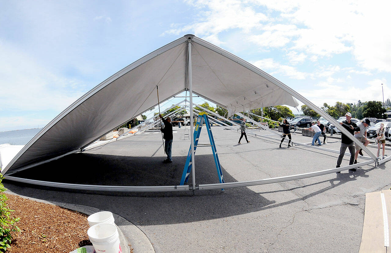 A crew erects an activity tent on Thursday in the parking lot of Port Angeles City Pier in preparation for todays Independence Day events. For a list of July 4 activities, see www.peninsuladailynews.com/entertainment/fourth-of-july-events-set-on-peninsula/. (KEITH THORPE/PENINSULA DAILY NEWS)