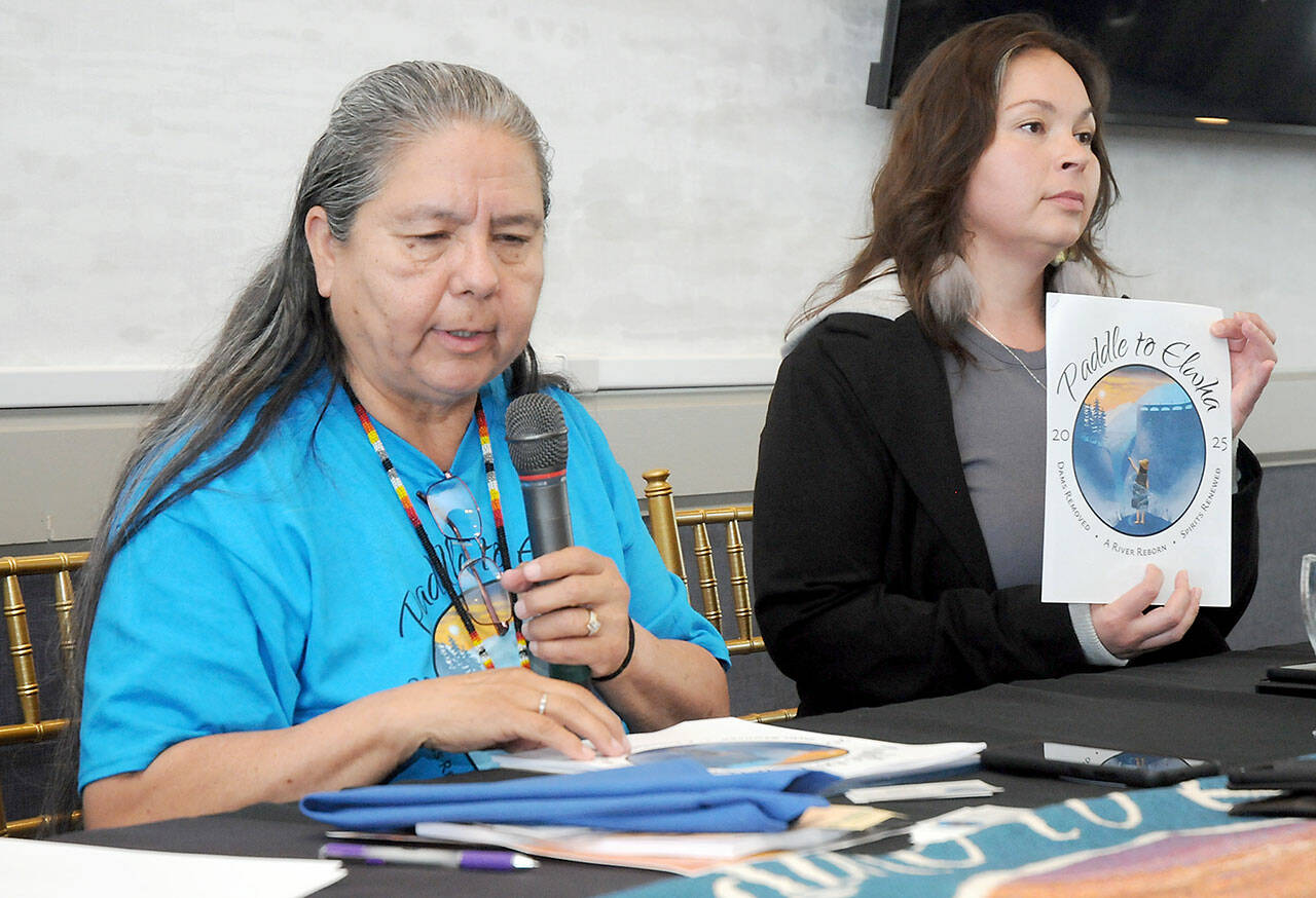 Lower Elwha Klallm Tribal Chairwoman Frances Charles, left, speaks about the Paddle to Elwha 2025 canoe journey as Carmen Watson-Charles, the tribes cultural manager, holds an informational pamphlet during a presentation to the Port Angeles Chamber of Commerce on Wednesday. (Keith Thorpe/Peninsula Daily News)