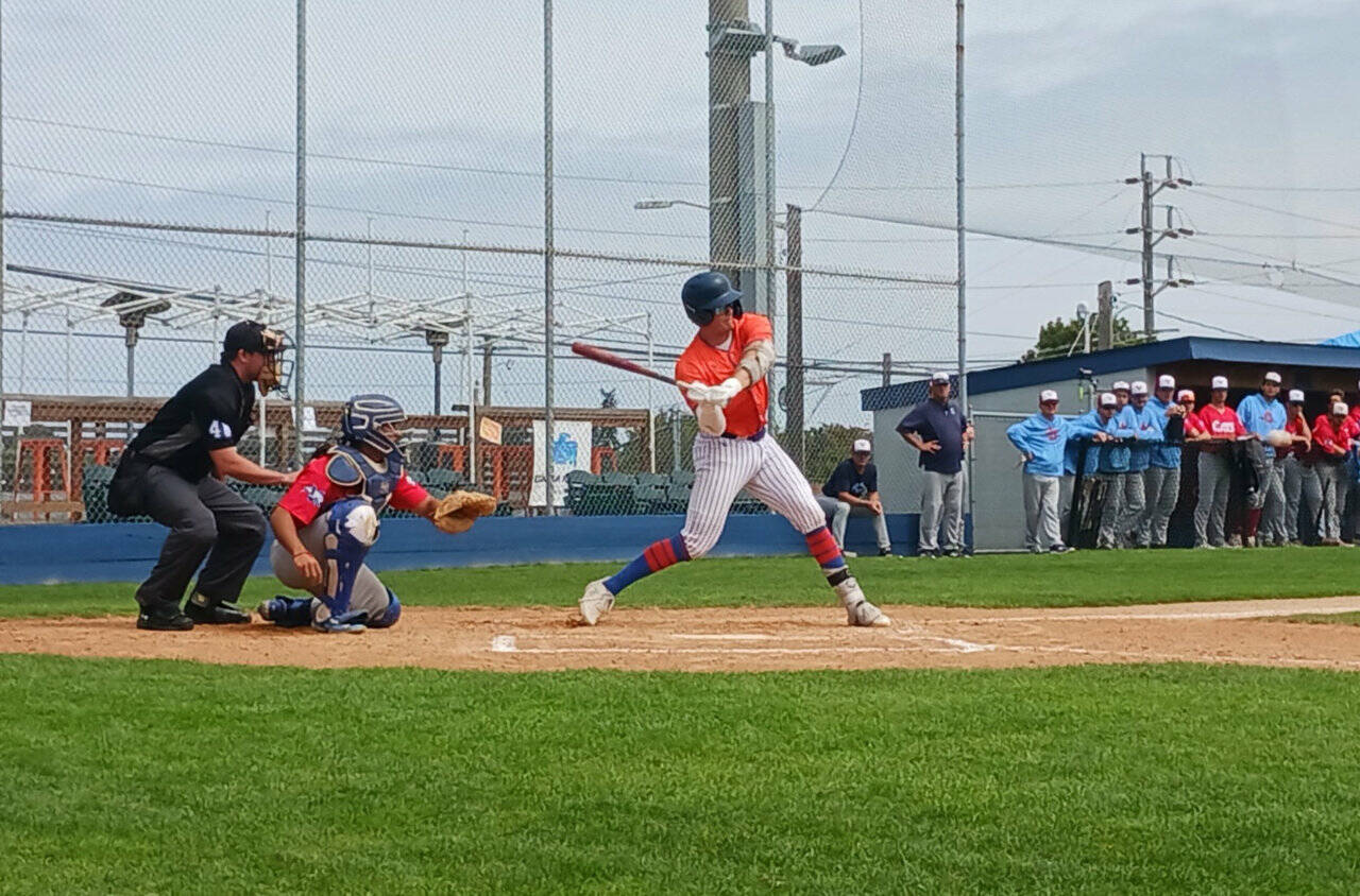 Port Angeles Jack Edmunds hits an RBI single in the first inning against the Victoria HarbourCats. (Pierre LaBossiere/Peninsula Daily News)