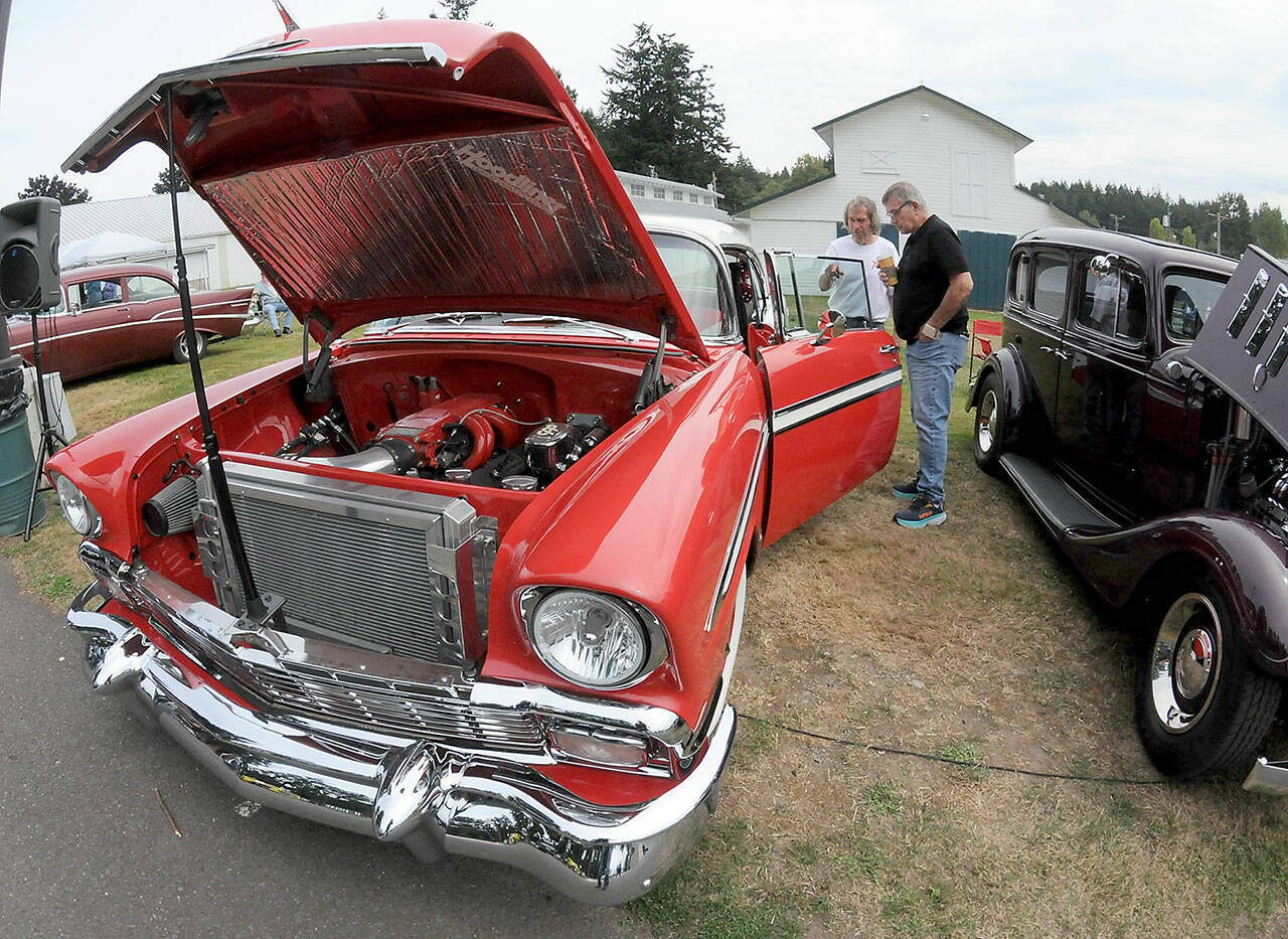 Vintage car owner Alfred Dese of Port Angeles, left, describes automotive details to Bob York of Port Angeles as they examine Deses 1956 Chevrolet Bel Air during Saturdays fourth annual John Burkheimer Memorial Car Show & Chili Cook-Off at the Clallam County Fairgrounds. Dozens of antique and vintage automobiles were featured at the event, which also included the cookoff as well as other food and music as a benefit for the Kiwanis Club of Port Angeles, which hosted the show. (Keith Thorpe/Peninsula Daily News)