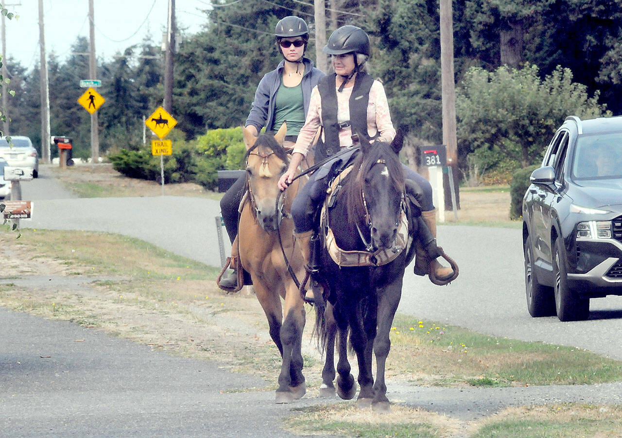 Julie Kustura and her horse Rocky, front, and Kari Olson riding Spirit, make their way down an equestrian trail paralleling the Olympic Discovery Trail along Vautier Road west of Sequim on Thursday. The pair were on their way to nearby Robin Hill Farm County Park and its collection of horse and pedestrian trails. (Keith Thorpe/Peninsula Daily News)