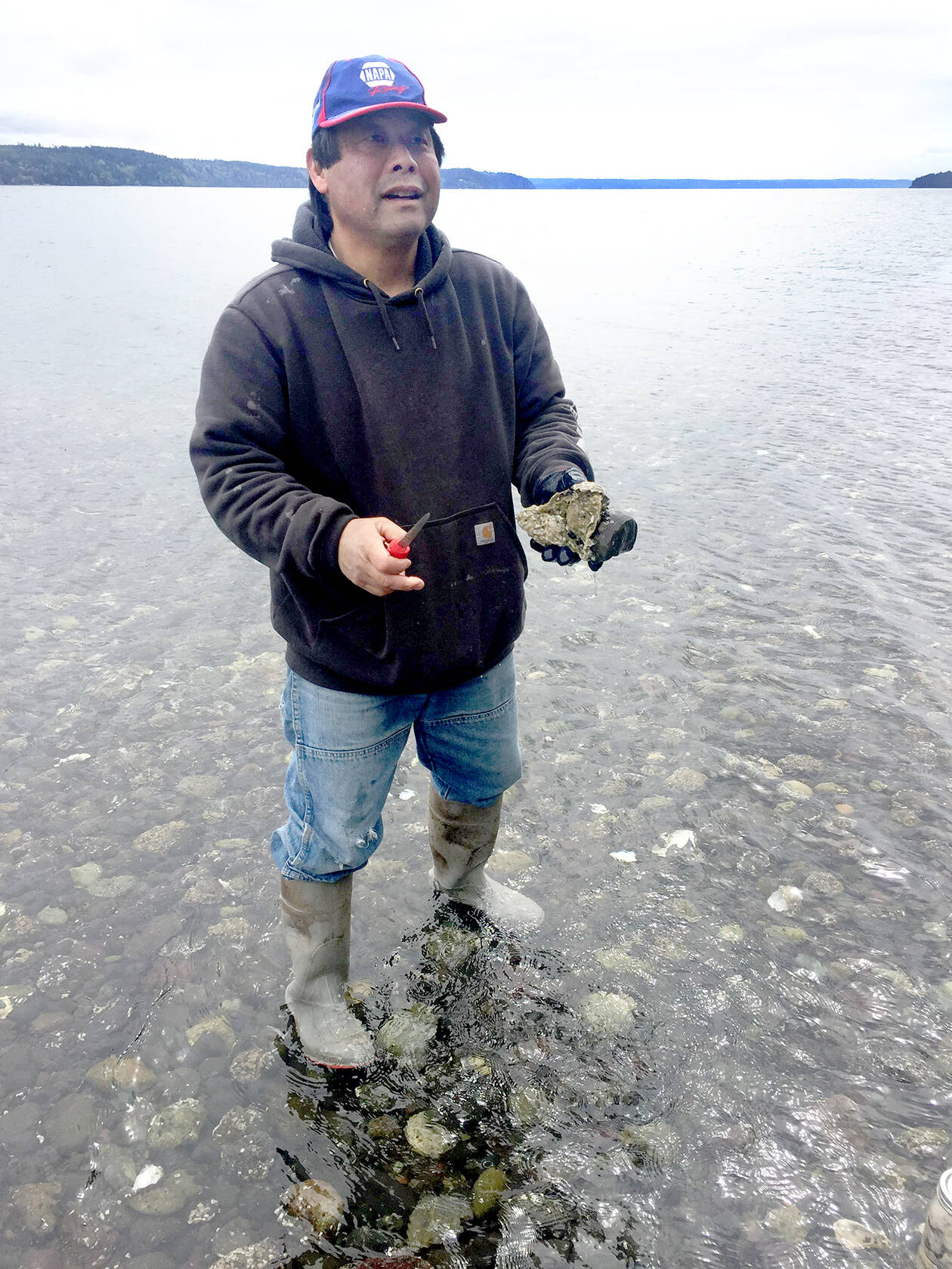 Joel Kawahara holds an oyster in Dabob Bay in 2018. (Kellie Henwood)