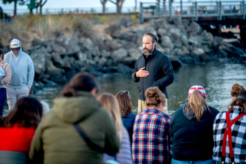Jeremy Pederson of Sequim leads a prayer during a gathering at Hollywood Beach in Port Angeles on Thursday honoring the life of conservative activist Charlie Kirk, who was killed by a single shot in a targeted attack during an outdoor event Wednesday at Utah Valley University. About 100 people attended the vigil. (Jesse Major/for Peninsula Daily News)