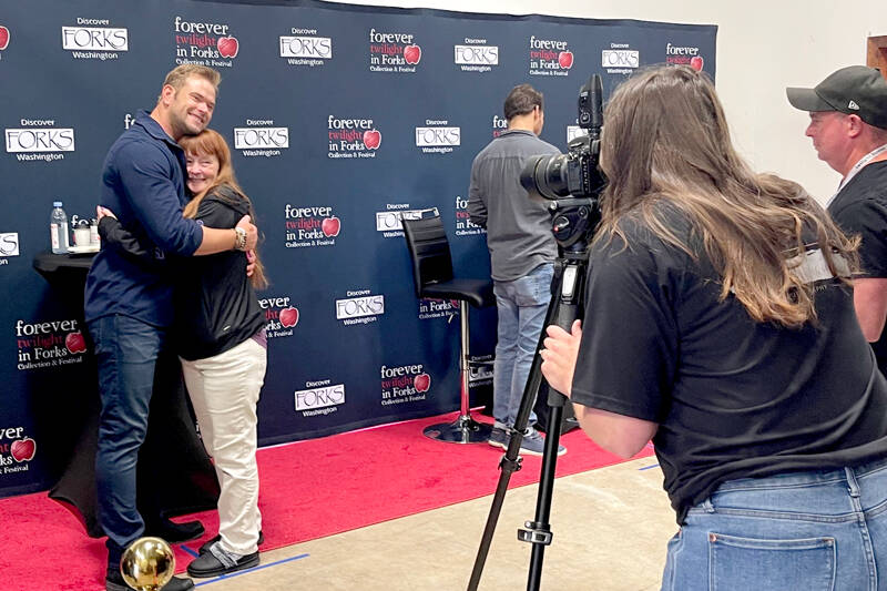Actor Kellan Lutz, left, hugs a fan during a “meet the actors photo session” during the Forever Twilight Forks event on Friday. All VITs had the opportunity for a photo and to get one item signed. Lutz played Emmett Cullen in The Twilight Saga film series. Also attending were Peter Facinelli, who played Dr. Cullen, seen at right, and actor and regular participant Erik Odom. Author Stephenie Meyer attended for the first time in many years. An estimated 1,000 people attended the Q&A with Meyer and movie at the Kitla Center. (Christi Baron/Olympic Peninsula News Group)